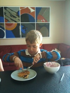 Ben practicing his cutlery skills on actual food